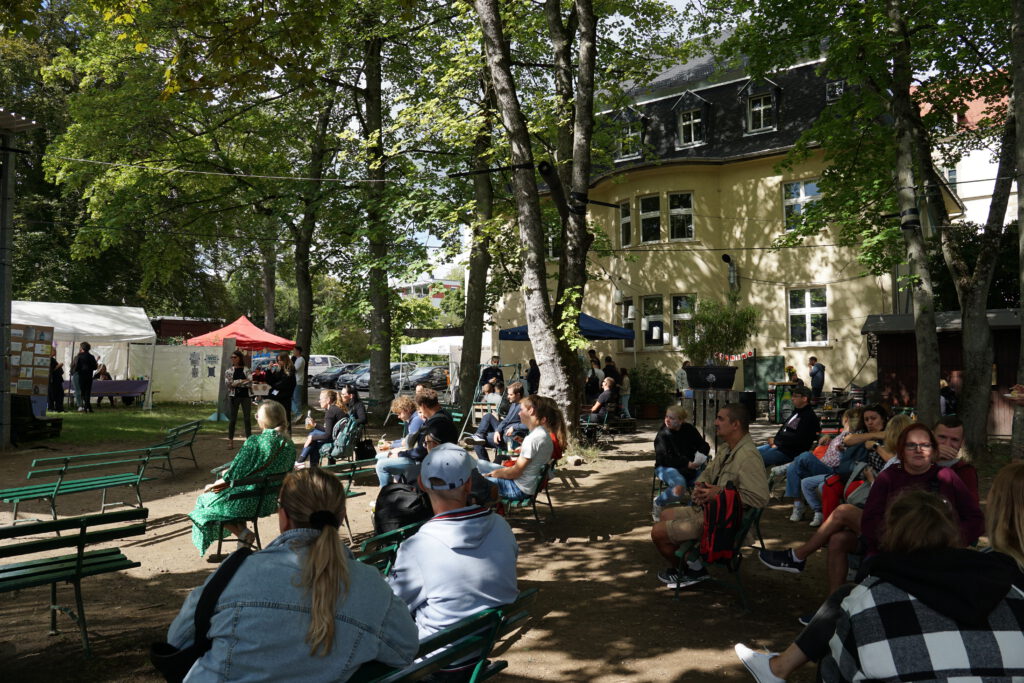 Das Publikum der Ideengarage bei sonnigen Wetter im Hof des Haus Arthur